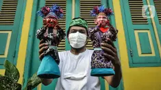 Masudi alias Bang Ntong Salam (40) menunjukkan miniatur ondel-ondel di Jalan Gang 3, Kelurahan Pondok Kopi, Kecamatan Duren Sawit, Jakarta Timur, Selasa (19/10/2021). Pandemi COVID-19 tak menyurutkan semangat ayah dua anak ini untuk melestarikan budaya Betawi. (merdeka.com/Iqbal S. Nugroho)
