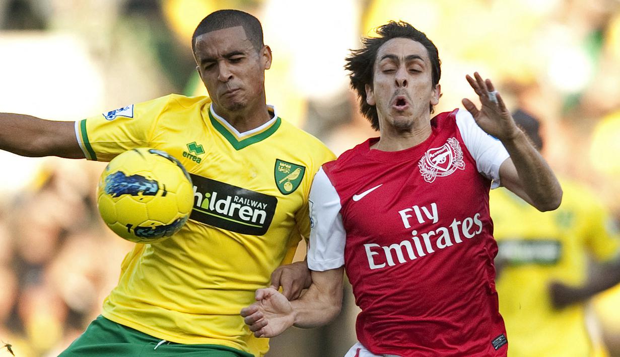 Pemain Arsenal, Yossi Benayoun (kanan) berebut bola dengan pemain Norwich City, Kyle Naughton pada laga lanjutan Liga Inggris 2011/2012 di Carrow Road Stadium, Norwich, 19 November 2011. Benayoun pernah berseragam The Gunners pada 2011 saat dirinya berstatus sebagai pemain pinjaman. (AFP/Adrian Dennis)