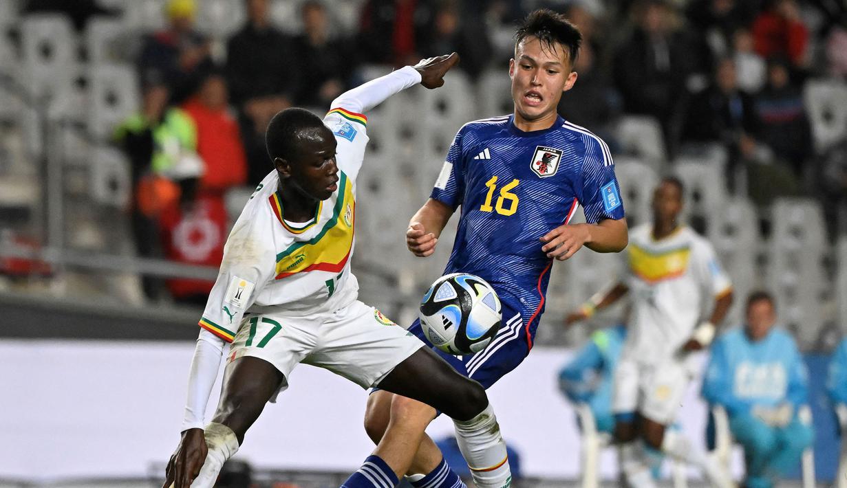 Pemain Timnas Jepang U-20, Niko Takahashi (kanan) berebut bola dengan pemain Senegal, Mame Mor Faye pada laga pertama Grup C Piala Dunia U-20 2023 di Estadio Unico Diego Armando Maradona stadium in La Plata, Argentina, on May 21, 2023. (AFP/Luis Robayo)