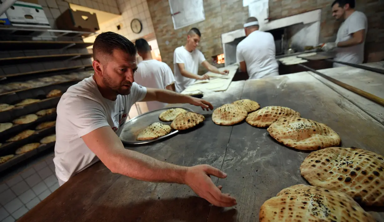 Pekerja membuat somun di sebuah toko roti di kota tua Sarajevo, Bosnia and Herzegovina, Kamis (30/4/2020). Roti somun menjadi sajian khas untuk sahur dan berbuka puasa saat Ramadan di Bosnia. (ELVIS BARUKCIC/AFP)