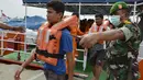Personel TNI memandu sukarelawan yang bertindak sebagai pengungsi selama simulasi penyelamatan pengungsi luar negeri di perairan Banda Aceh, Kamis (17/10/2019). Kegiatan diikuti unsur TNI, Polri, relawan dan pimpinan lembaga peduli bencana di Aceh. (CHAIDEER MAHYUDDIN/AFP)