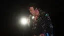 Kontestan yang bernama Neil Vincent tampil diatas panggung saat mengikuti Kejuaraan Elvis Eropa di Hilton Metropole Hotel di Birmingham, Inggris (5/1). Kompetisi mirip penyanyi legendaris Elvis Presley ini digelar setiap tahunnya. (AFP Photo/Oli Scarff)