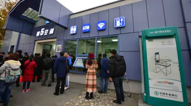 Warga mengantre di luar toilet umum pertama yang dilengkapi Wi-fi, mesin ATM hingga tempat pengisian energi untuk ponsel dan mobil listrik di Beijing, Kamis (19/11). Toilet ini juga akan dibuka di pinggiran kota Beijing dan kota lain.(CHINA OUT AFP PHOTO)