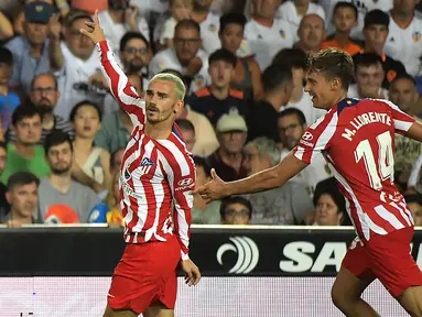 Penyerang Atletico Madrid, Antoine Griezmann (kiri) berselebrasi usai mencetak gol ke gawang Valencia pada pertandingan lanjutan La Liga Spanyol di stadion Mestalla di Valencia (30/8/2022). Atletico Madrid menang tipis atas tuan rumah Valencia 1-0. (AFP/Jose Jordan)