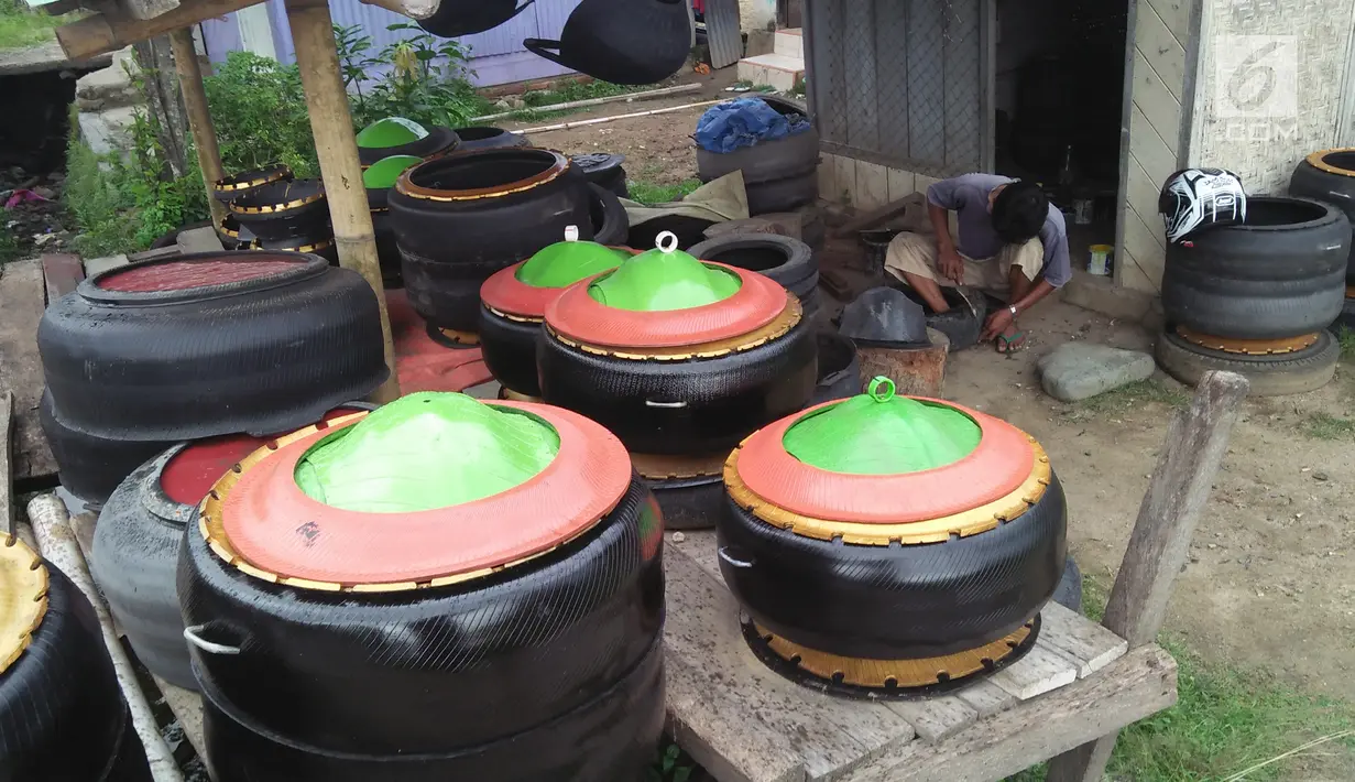 Agus Baiku mengolah ban bekas menjadi produk berkelas di Desa Pentadio Barat, Kabupaten Gorontalo, Senin (31/12). Ban mobil bekas ditempat ini diubah menjadi tempat sampah, loyang, ayunan anak-anak serta pot bunga. (Liputan6.com/Arfandi Ibrahim)