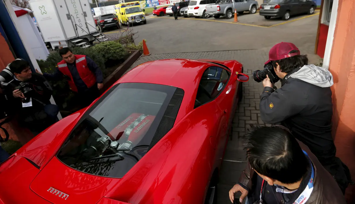 Gelandang Chile, Arturo Vidal saat berada didalam mobil ferrari miliknya saat tiba untuk menghadiri sesi latihan bersama timnas Chile yang bermain dalam Copa America 2015, (9/6/2015). (REUTERS/Ivan Alvarado)