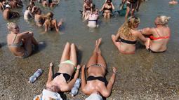Peserta menikmati musik sambil menikmati air sungai Danube selama festival musik Sziget di Budapest , Hongaria, Rabu (12/8/ 2015).  Festival ini diselenggarakan karena suhu panas yang melanda Hongaria hingga 38 derajat. (REUTERS/Laszlo Balogh)