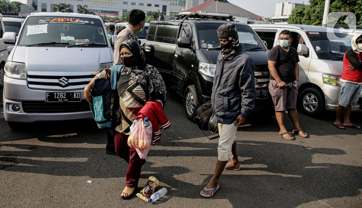 Penumpang yang terjaring razia travel gelap Ditlantas Polda Metro Jaya dipulangkan ke daerah asalnya, Jakarta, Kamis (29/4/2021). Sebanyak 115 kendaraan travel gelap diamankan karena diduga kuat mengangkut pemudik di tengah masa pengetatan larangan mudik 2021. (Liputan6.com/Faizal Fanani)