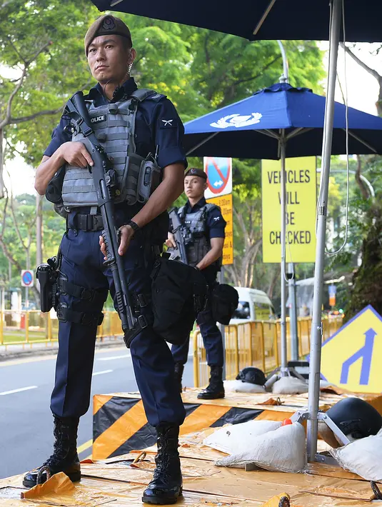 Gaya pasukan Gurkha saat berjaga di luar Hotel Shangri-La, Singapura, Minggu (10/6). Pasukan Gurkha akan mengamankan lokasi pertemuan, hotel para delegasi, serta jalan di sekitarnya. (Ted ALJIBE/AFP)
