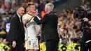 Pemain Real Madrid, Toni Kroos (tengah) menyalami pelatih Carlo Ancelotti saat upacara perpisahan setelah laga Liga Spanyol 2023/2024 melawan Real Betis di Santiago Bernabeu, Madrid, Spanyol, Minggu (26/05/2024) dini hari WIB. Kroos memutuskan untuk pensiun dari sepak bola setelah Euro 2024 nanti. (AFP/Javier Soriano)