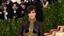 Kris Jenner berupaya untuk membetulkan jumpsuit yang digunakan Kendall Jenner saat di Met Gala. (Angela WEISS / AFP)