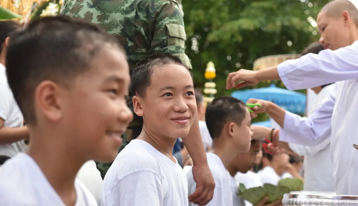 Biksu mencukur rambut anak-anak, yang diselamatkan dari gua di Thailand, pada upacara pentahbisan di Kuil Wat Phra That Doi Wao, Chiang Rai, Selasa (24/7). 11 dari 12 remaja itu menjalani ritual menjadi biksu. (Panumas Sanguanwong/THAI NEWS PIX/AFP)