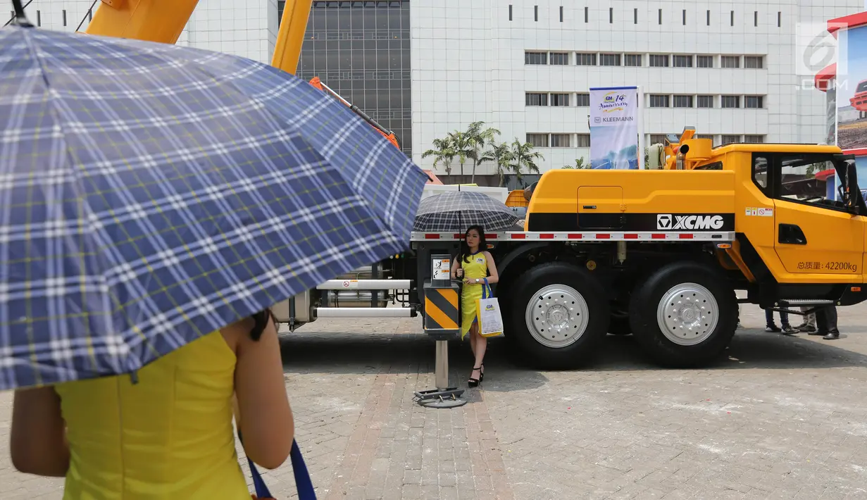 Model berdiri dekat alat berat GMTractors pada pameran industri Mining Indonesia di JIExpo Kemayoran, Jakarta, Rabu (18/9/2019). Distributor yang berdiri sejak tahun 2005 memasarkan alat berat Jepang dan berkontribusi dalam pembangunan berkelanjutan di Indonesia. (Liputan6.com/Fery Pradolo)