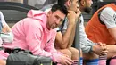 Pemain Inter Miami, Lionel Messi duduk di bangku cadangan saat pertandingan persahabatan melawan Tim Hong Kong All Stars di Stadion Hong Kong, Hong Kong, Minggu, 4 Februari 2024 waktu setempat. (AFP/Peter Parks)