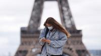 Seorang perempuan yang mengenakan masker berjalan-jalan di Istana Trocadero tak jauh dari Menara Eiffel di Paris, 10 Juli 2020. Dengan 25 kematian baru yang dicatat dalam 24 jam terakhir, jumlah kematian terkait corona COVID-19 di Prancis naik menjadi 30.004 pada Jumat (10/7). (Xinhua/Gao Jing)
