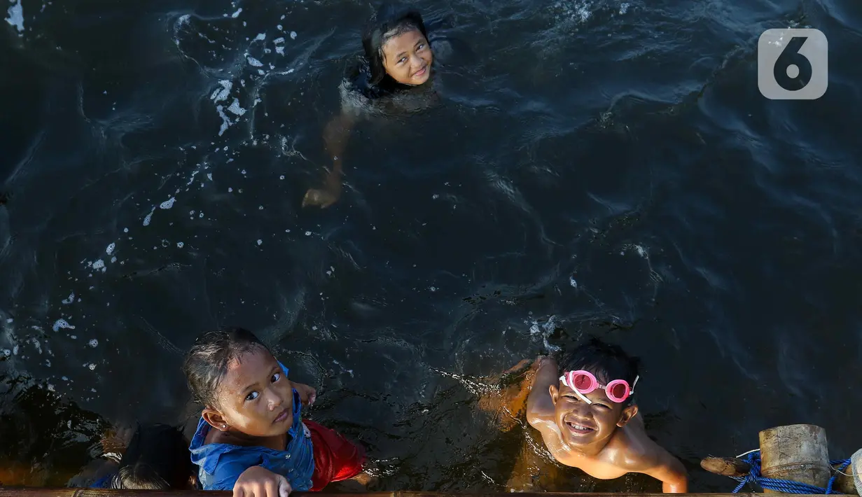 Anak-anak berenang di Pantai Marunda, Jakarta Utara, saat libur Kenaikan Yesus Kristus, Kamis (9/5/2024). (Liputan6.com/Herman Zakharia)