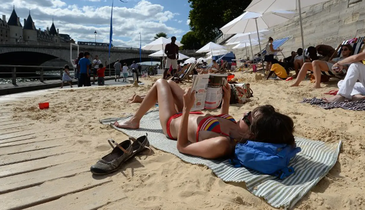 Para wisatawan berjemur di pantai buatan Paris Plages , Perancis, Rabu (22/7/2015).  Tahun ini adalah edisi ke-14 dari Paris Plages, acara budaya dan wisata utama di Paris selama musim panas. (AFP Photo/Miguel Medina)