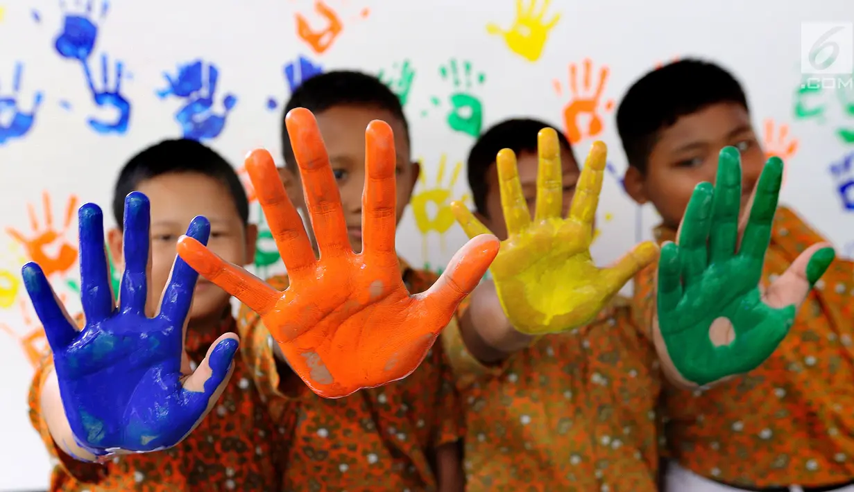 Empat siswa menunjukkan tangan berlumuran cat air di SD Negeri 15 Karet Tengsin, Jakarta, Rabu (18/10). Kegiatan yang diadakan operator penyedia air Palyja digelar dalam rangka Hari Cuci Tangan Pakai Sabun Sedunia. (Liputan6.com/Fery Pradolo)