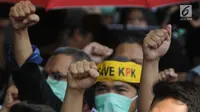 Pegawai KPK membawa poster saat menggelar aksi di Lobi Gedung KPK, Kuningan, Jakarta, Jumat (6/9/2019). Dalam aksi menolak revisi UU KPK tersebut, mereka mengenakan baju serba hitam lengkap dengan masker penutup mulut dan membawa payung. (merdeka.com/Dwi Narwoko)