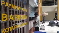 Seorang warga Pekanbaru membayar pajak di salah satu loket bank yang disediakan pemerintah setempat. (Liputan6.com/M Syukur)