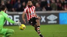 Striker Brentford, Bryan Mbeumo mencetak gol ke gawang Liverpool yang dijaga Alisson Becker pada laga Liga Inggris 2022/2023 di Gtech Community Stadium, London (2/1/2023). Bryan Mbeumo tampil di Liga Inggris bersama Brentford yang telah diperkuatnya sejak awal musim 2019/2020. Ia ikut membawa Brentford promosi ke Premier League pada awal musim 2021/2022. Hingga kini ia telah tampil dalam 73 laga di Premier League dengan torehan 13 gol dan 15 assist. (AFP/Adrian Dennis)