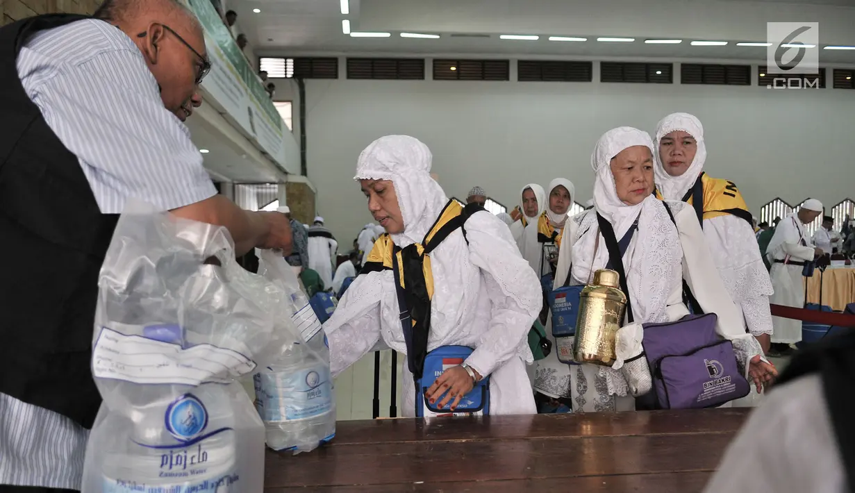 Petugas membagikan air zam-zam untuk jemaah haji Kloter 2 asal Banten di Asrama Haji Pondok Gede, Jakarta, Rabu (29/8). Setiap jemaah mendapatkan lima liter air zam-zam yang dibagikan secara cuma-cuma (Merdeka.com/ Iqbal S. Nugroho)