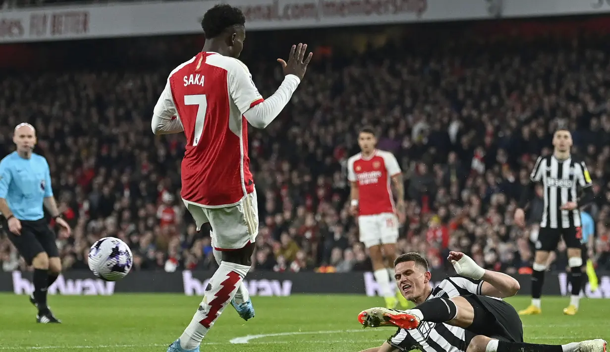 Pemain Arsenal, Bukayo Saka (kiri) berusaha mencetak gol namun digagalkan pemain Newcastle United, Sven Botman pada laga lanjutan Liga Inggris 2023/2024 di Emirates Stadium, London, Inggris, Minggu (25/02/2024) dini hari WIB. (AFP/Justin Tallis)