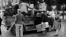 Warga Paris mamasukan barang-barang ke van yang digunakan sebagai transportasi umum, pada Oktober 1944 di Paris, beberapa bulan setelah Pembebasan Paris, selama Perang Dunia Kedua. (AFP Photo)