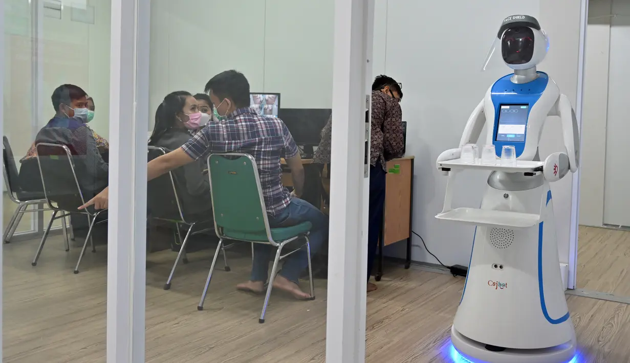 Robot Amy membawa nampan berisi air kemasan saat simulasi membantu petugas medis dalam menangani pasien virus corona COVID-19 di Rumah Sakit Pertamina Jaya (RSPJ), Jakarta, Kamis (16/4/2020). Amy akan digunakan untuk membawa makanan, obat, dan segala kelengkapan lain untuk pasien. (ADEK BERRY/AFP)