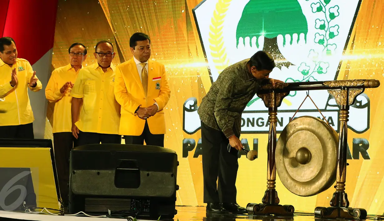 Menkopolhukam Wiranto memukul gong Ketum Partai Golkar, Setya Novanto saat pembukaan Pertemuan Nasional - 1 Legislatif dan Eksekutif di Jakarta, Senin (26/9). Acara dihadiri kepala daerah dari kader  Golkar Se Indonesia. (Liputan6/JohanTallo)
