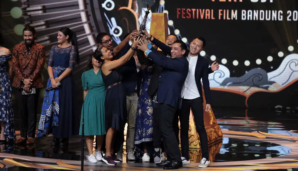 Kebahagiaan Ernest semakin bertambah, lantaran film Cek Toko Sebelah juga menang sebagai Film Bioskop Terpuji. Ungkapan bahagia terlihat dari pihak yang terlibat di film tersebut saat menerima piala di atas panggung. (Deki Prayoga/Bintang.com)
