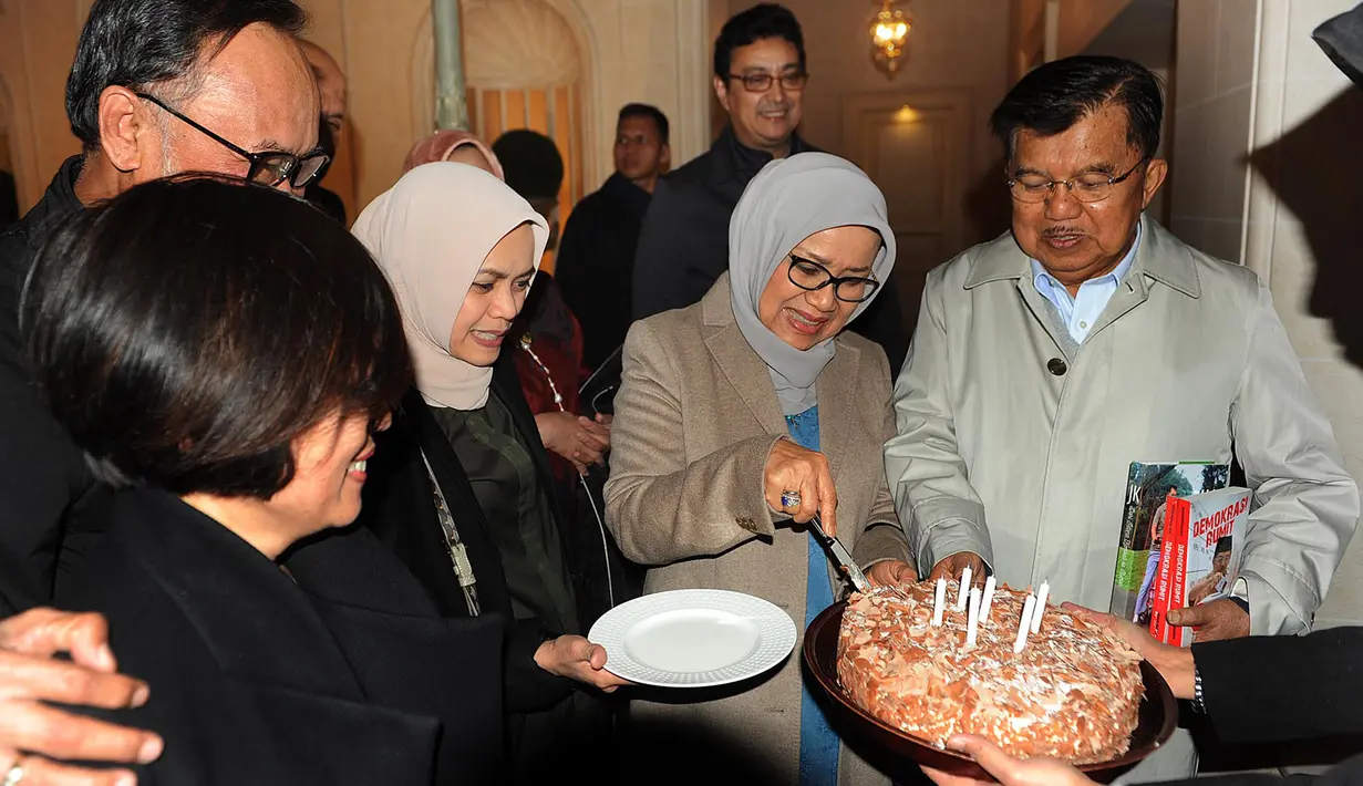 Mufidah Kalla memotong kue dan memberikannya kepada Wakil Presiden Jusuf Kalla seusai acara kejutan ulang tahun ke-77 di Jenewa, Swiss, Rabu (15/5/2019). JK berkunjung ke Swiss untuk menghadiri sebuah pertemuan yang diinisiasi PBB dengan bahasan penanganan bencana. (Liputan6.com/Tim Media Wapres)