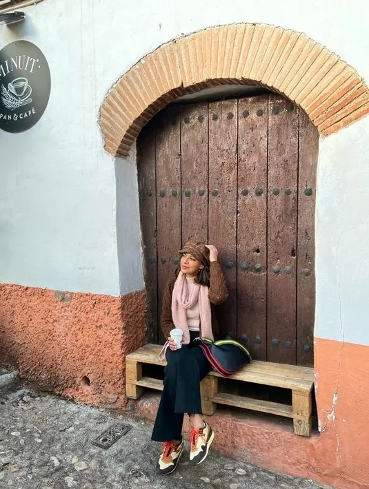 Menarik untuk menyimak pilihan outfit Najwa Shihab saat dirinya berlibur keluar negeri. Ia tampak mengenakan outfit musim dingin; sweater rajut cokelat, dipadu dengan celana jeans, Najwa juga mengenakan syal merah muda dan topi cokelat yang serasi. Foto: Instagram.