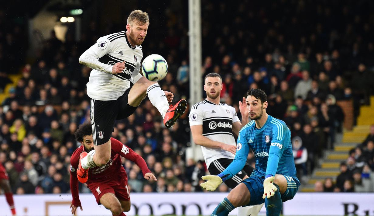 Penyelamatan dilakukan bek Fulham, Tim Ream pada laga lanjutan Premier League yang berlangsung di Stadion Craven Cottage, London, Minggu (17/3). Liverpool menang 2-1 atas Fulham. (AFP/Glyn Kirk)