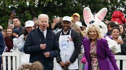 Presiden AS Joe Biden dan Ibu Negara Jill Biden menonton perayaan tahunan Telur Paskah Gedung Putih di halaman Selatan Gedung Putih pada 18 April 2022. Untuk pertama kalinya sejak 2019, Gedung Putih kembali menjadi tuan rumah Telur Paskah Tahunan (Easter Egg Roll) tahunan. (Stefani Reynolds / AFP)