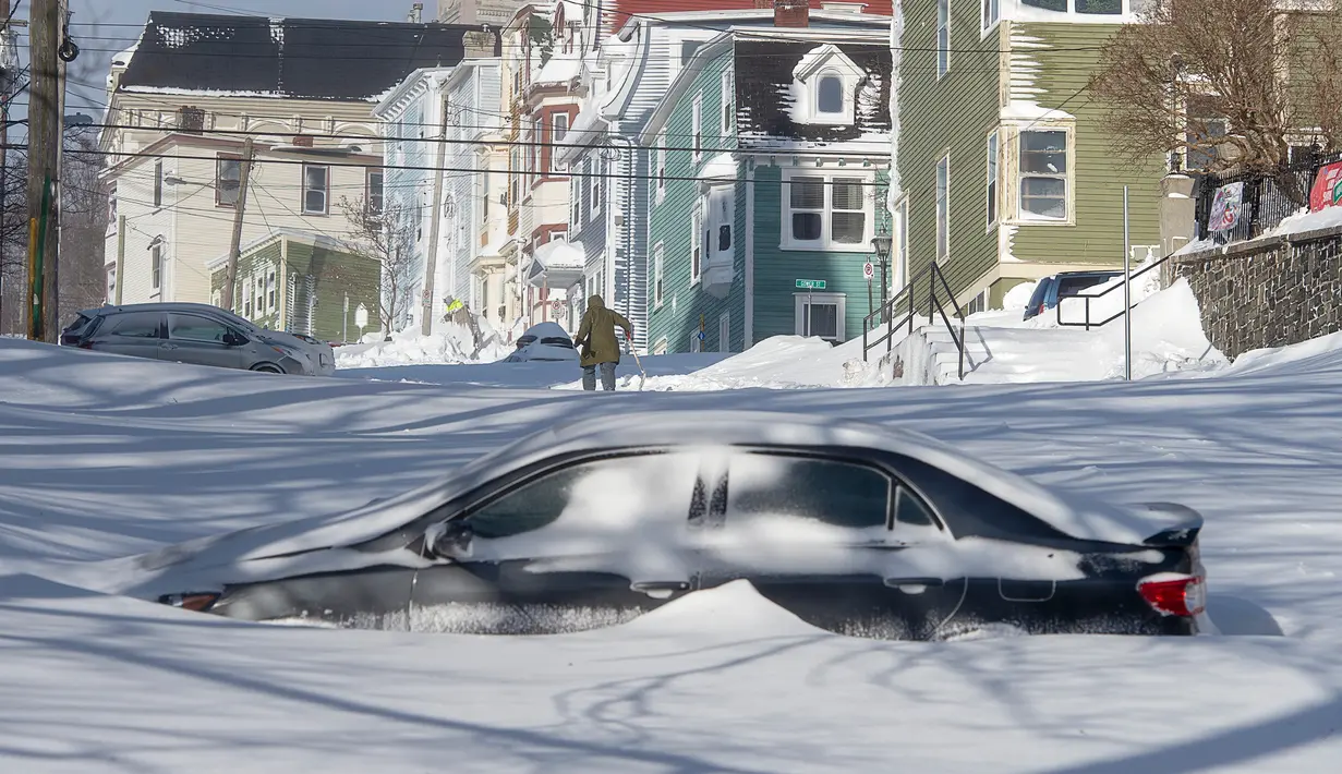 Sebuah mobil setengah terkubur salju di Kota St John's, Newfoundland, Kanada, Sabtu (18/1/2020). St John's menghadapi keadaan darurat ketika salju tebal memaksa pusat-pusat bisnis tutup dan kendaraan dilarang melintas di jalan raya. (Andrew Vaughan/The Canadian Press via AP)