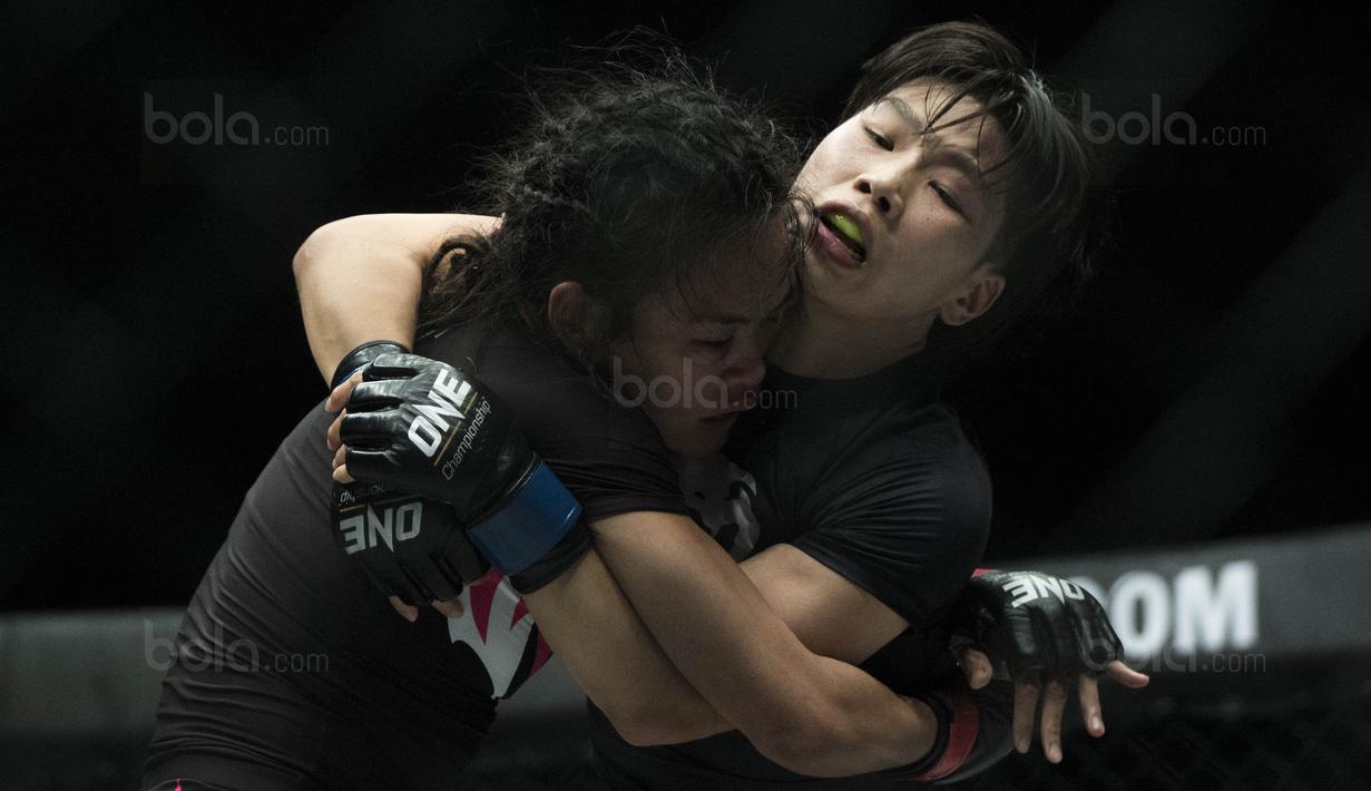 Petarung Cina, Xiong Jing Nan, mengunci petarung Singapura, Tiffany Teo, saat laga One Championship di JCC Senayan, Jakarta, Sabtu (20/1/2018). Jing Nan berhasil merebut juara dunia kelas jerami. (Bola.com/Vitalis Yogi Trisna)