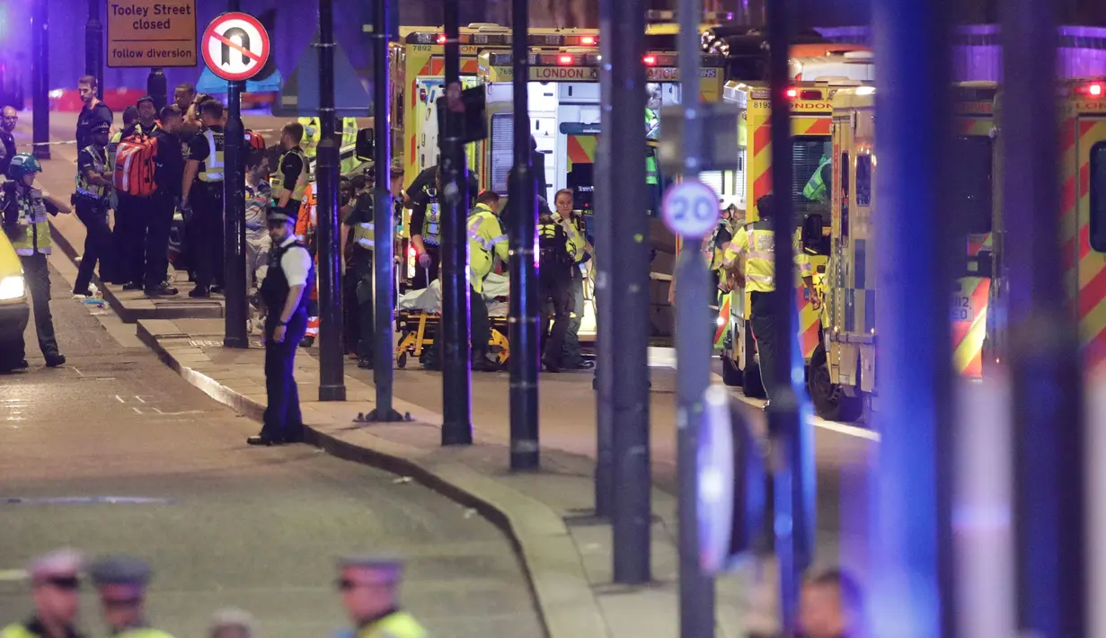 Petugas medis memberikan pertolongan kepada korban serangan teror di dekat London Bridge, Inggris, Sabtu (3/6). Teror terjadi ketika sebuah mobil van melaju kencang dan menghantam para pejalan kaki yang berada di kawasan itu. (Yui Mok/PA via AP)