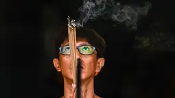 Suasana perayaan tahun ini diwarnai dengan rasa empati yang mendalam bagi para korban bencana alam yang melanda wilayah Aceh baru-baru ini. Tampak dalam foto, seorang pria membakar dupa saat berdoa di sebuah kuil pada hari pertama Tahun Baru Imlek 2577 Kongzili di Banda Aceh, Provinsi Aceh, pada Selasa 17 Februari 2026. (CHAIDEER MAHYUDDIN/AFP)