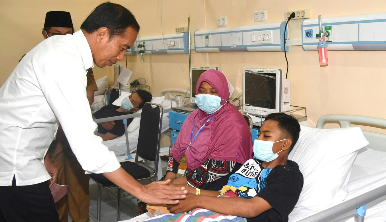 Di sana, ia bertemu dengan keluarga korban Tragedi Kanjuruhan. Ia pun memberikan santunan kepada keluarga korban. (AFP/Handout/Indonesia Presidential Palace)