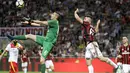 Kiper Benevento, Chistian Puggioni (kiri) menghalau bola dari sundulan pemain AC Milan, Patrick Cutrone pada laga Serie A di San Siro stadium, Milan, (21/4/2018). AC Milan kalah 0-1. (AP/Luca Bruno)