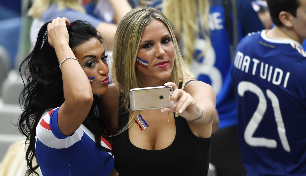 Dua Suporter Prancis berfoto selfie saat menyaksikan laga grup B Prancis melawan Rumania di Stade de France, Saint-Denis, (10/6/2016). (AFP/Miguel Medina)