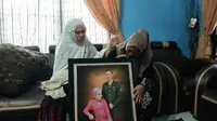 Istri Serma Rama, prajurit TNI gugur di Kongo, dan orangtuanya di rumah duka Jalan Garuda Sakti Kabupaten Kampar. (Liputan6.com/M Syukur)