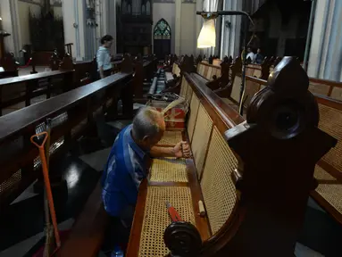 Samin (72) merajut anyaman kursi rotan ibadah umat Kristen di Gereja Katedral, Jakarta, Rabu (27/3) Bilau kerap melakukan perawatan kursi-kursi Katedral yang terbuat dari kayu Jati dengan anyaman rotan. Sudah 8 tahun untuk memberikan kenyamanan untuk bisa beribadah dengan baik. (merdeka.com/Imam Buh