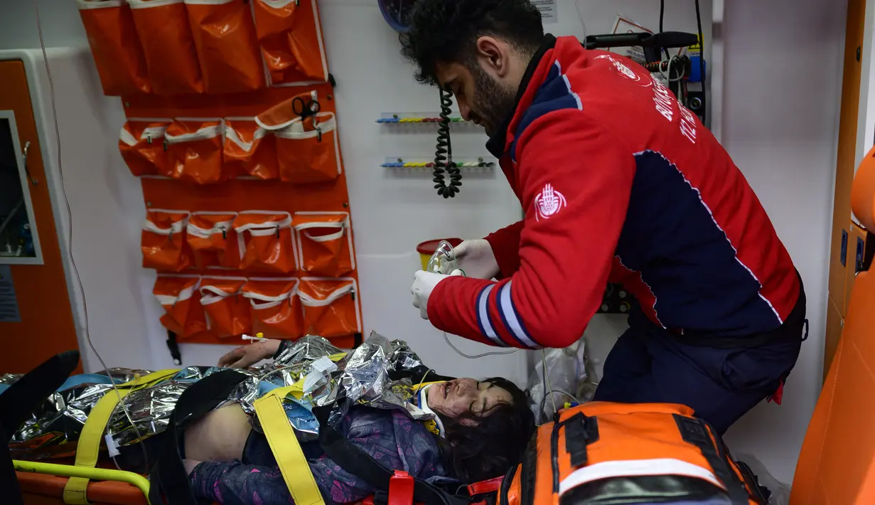 Seorang penyelamat merawat seorang gadis Suriah berusia 12 tahun, Cudi, yang dievakuasi dari puing-puing bangunan yang hancur di Hatay, Turki, setelah gempa berkekuatan 7,8 melanda tenggara negara itu, Minggu (12/2/2023). Pada jam ke-147 gempa di Hatay, tim SAR menarik Cudi dalam keadaan hidup dari puing-puing. (Photo by Yasin AKGUL / AFP)