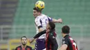 Pemain AC Milan, Theo Hernandez, duel udara dengan pemain Fiorentina, Dusan Vlahovic, pada laga Liga Italia di Stadion San Siro, Minggu (29/11/2020). AC Milan menang dengan skor 2-0. (AP/Luca Bruno)
