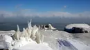 Es menutupi garis pantai Danau Michigan ketika suhu turun hingga -20 derajat F (-29C) di Chicago, Illinois, Rabu (30/1). Suhu di beberapa negara bagian AS menurun drastis, sampai diprediksi bakal lebih dingin dibanding Antartika. (JOSHUA LOTT / AFP)