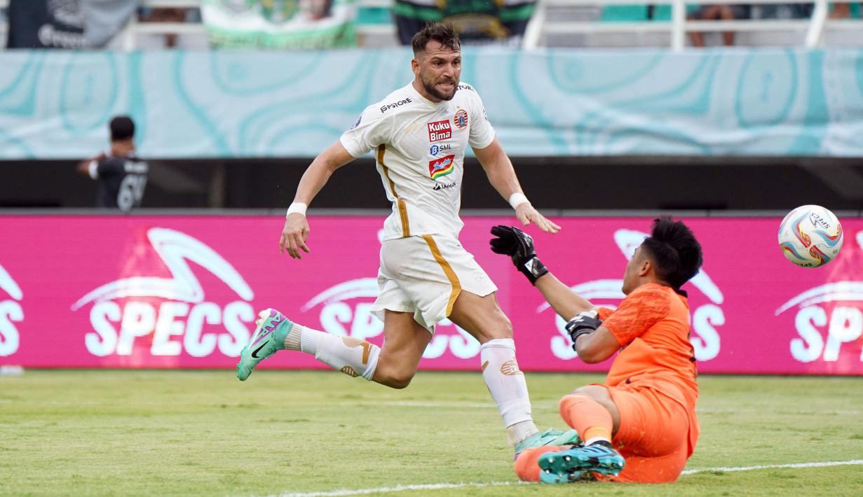 Pemain Persija Jakarta, Marko Simic (kiri), berusaha menjebol gawang Persebaya Surabaya yang dijaga oleh Ernando Ari, dalam pertandingan pekan ke-22 BRI Liga 1 2023/2024 yang berlangsung di Stadion Gelora Bung Tomo, Surabaya, Sabtu (9/12/2023). (Dok. Persija Jakarta)