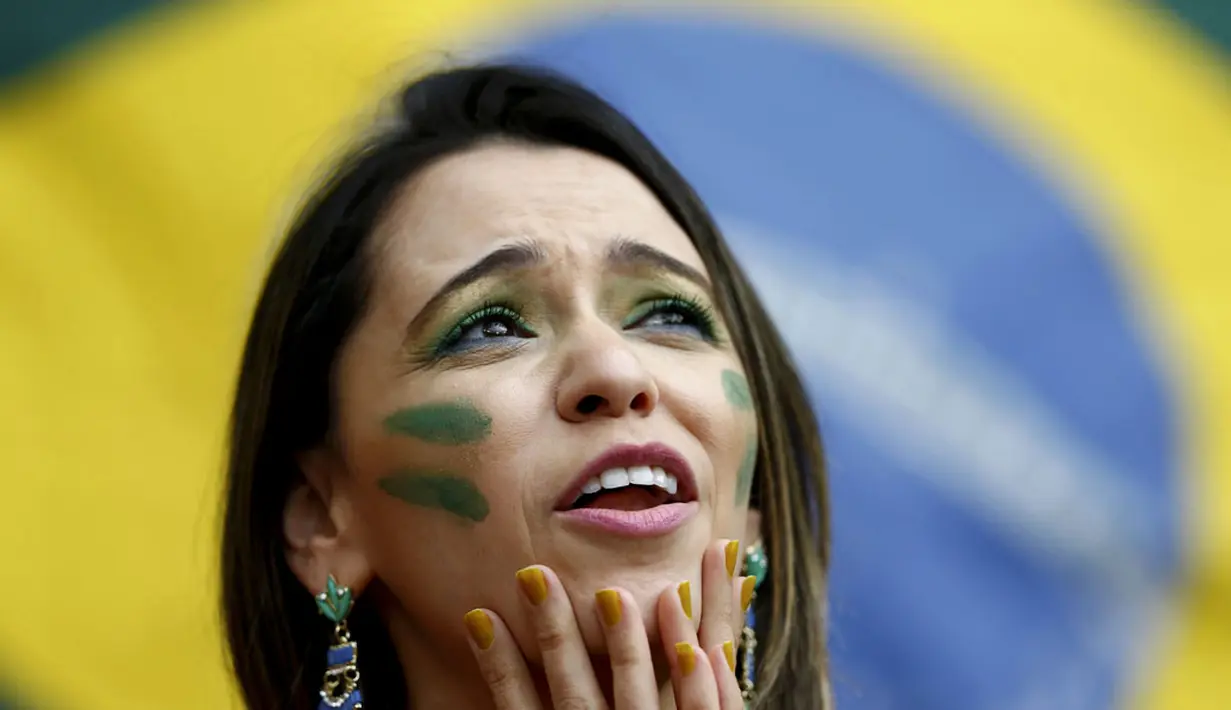 Ekspresi salah satu suporter tim Samba saat menunggu dimulainya laga yang mempertemukan Kamerun vs Brasil di Stadion Nasional Brasil, (23/6/2014). (REUTERS/Dominic Ebenbichler)