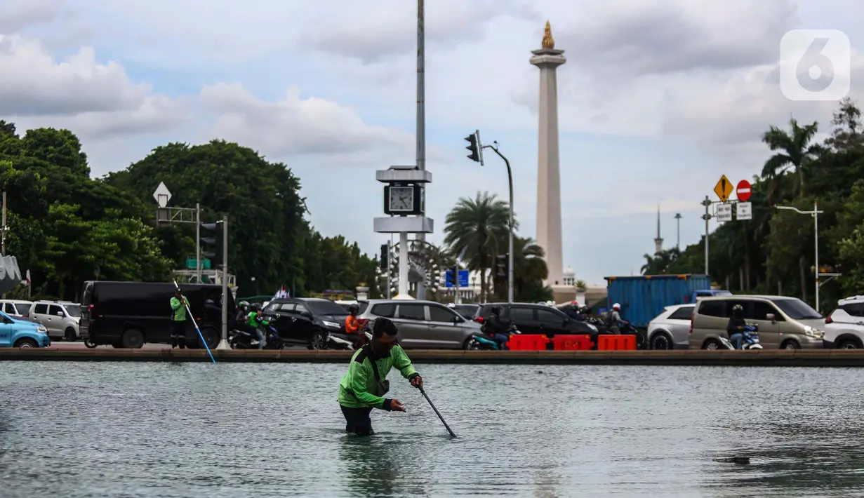 Pekerja dari Dinas Kehutanan Provinsi DKI Jakarta melakukan perawatan rutin kolam air di kawasan Patung Kuda, Jakarta, Jumat (8/3/2024). (Liputan6.com/Angga Yuniar)